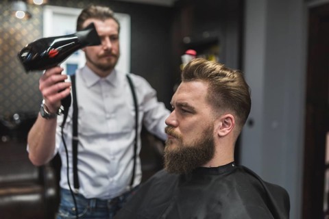 Hairdresser using drier hair client