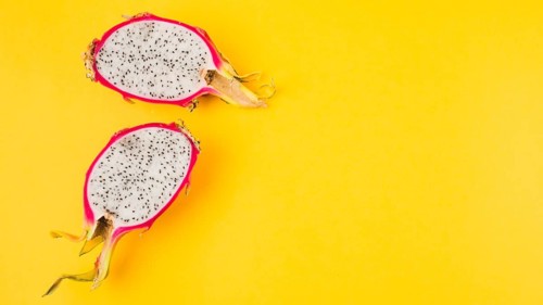 Halved dragon fruit yellow background