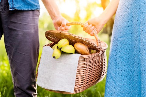 Hands couple holding picnic basket full food