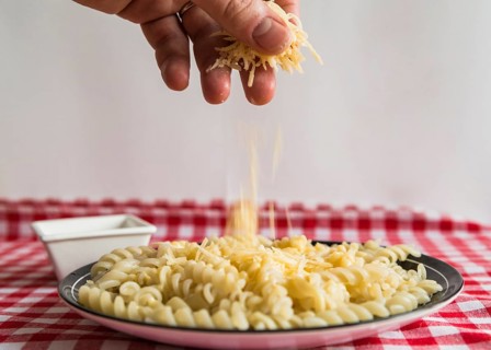 Hand sprinkling cheese pasta