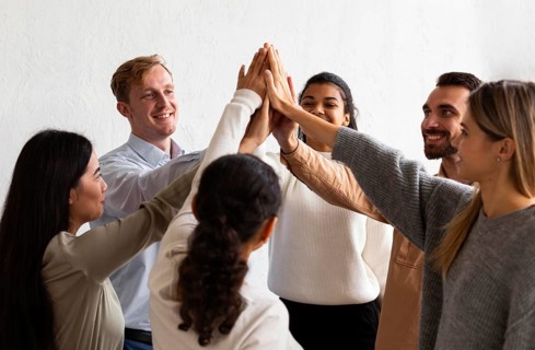 Happy people high fiving each other group therapy session