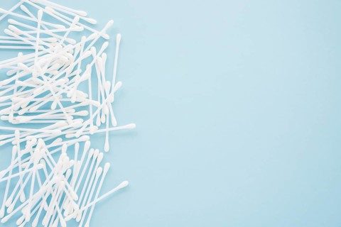 Heap cotton swabs blue background