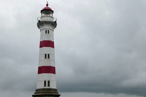 Lighthouse against dark overcast sky