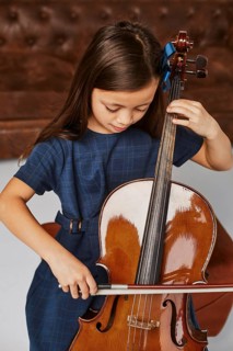 Little cute girl learning how play cello