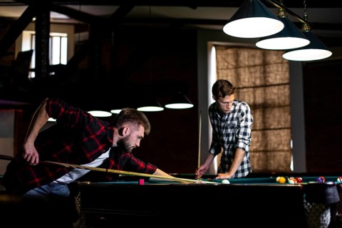 Low angle guys playing billiard club