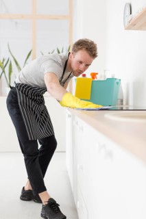 Low angle man cleaning kitchen