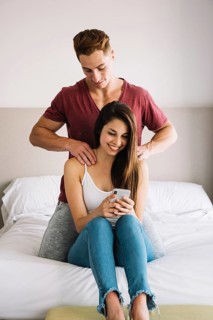 Man massaging shoulder woman bed
