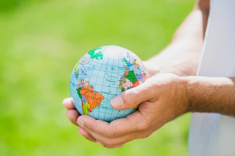 Man s hand holding small globe