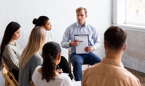 Man showing clipboard group therapy session