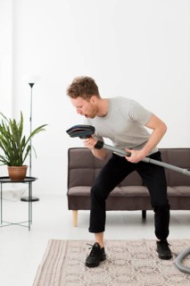 Man singing vacuum while cleaning