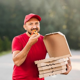 Medium shot delivery guy eating pizza