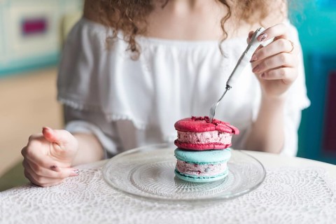 Midsection woman eating ice cream sandwich with fork