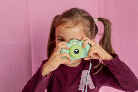 Portrait little girl playing with camera
