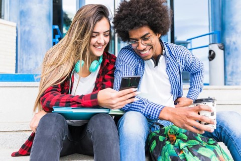 Portrait smiling diverse young students looking mobile phone