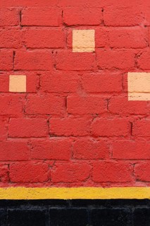 Red brick wall with yellow spots
