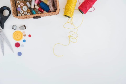Scissor buttons thimble red yellow yarn isolated white background