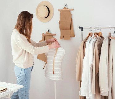 Side view female tailor studio with clothes