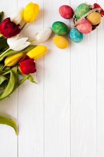 Small basket with eggs near tulips