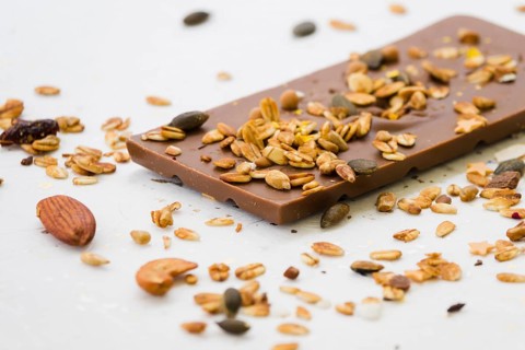 Spread dried fruits chocolate bar against white backdrop