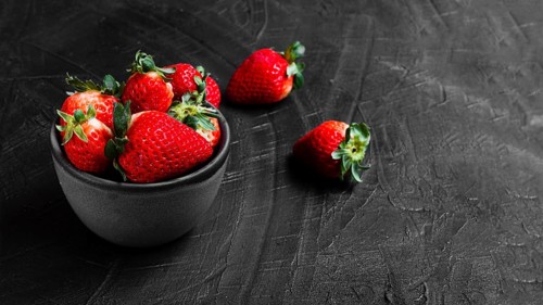 Strawberries bowl black table