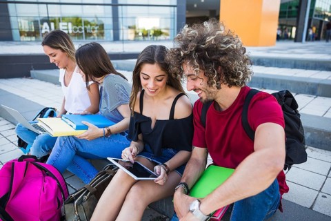 Students using tablet near friends
