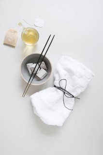 Teabag oil pumice stone incense stick tied napkin white surface