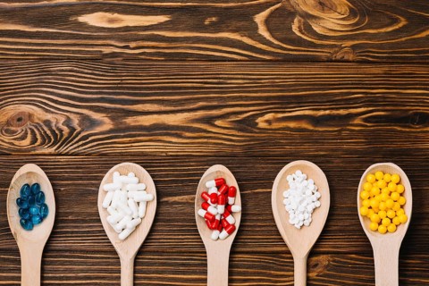 Various pills wooden spoon