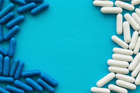 White blue candy capsules forming frame cyan background