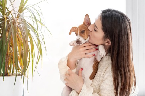 Woman giving her cute dog kiss