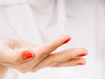 Woman holding contact lenses her finger