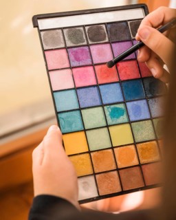 Woman s hand holding palette eye shadow powder