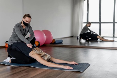 Workout with personal trainer stretching back