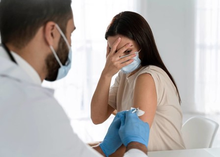 Young doctor doing vaccine frightened patient