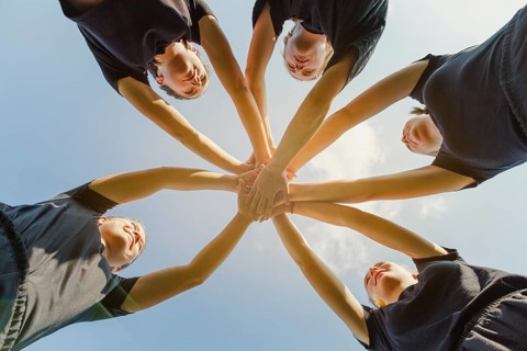 Young women putting hands together