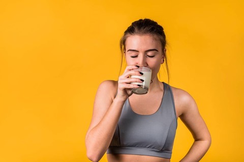 Attractive young woman sportswear drinking milk