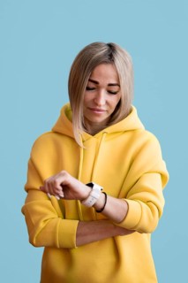 Blonde asian woman looking her smart watch