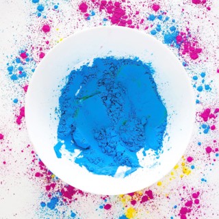 Blue holi color powder white bowl white backdrop