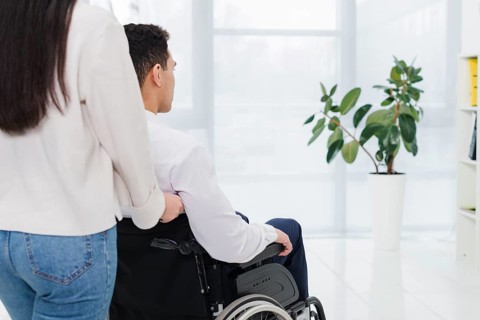 Close up man pushing woman wheelchair