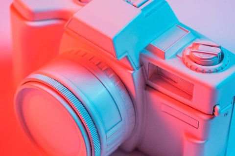 Close up retro pink camera with blue light