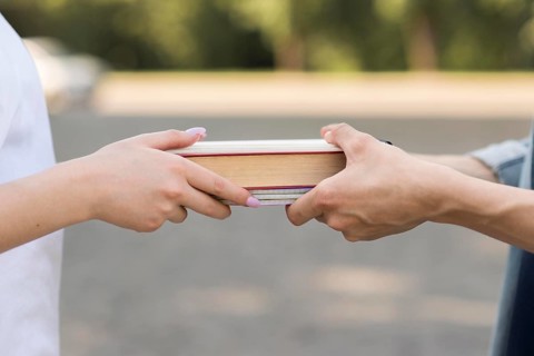 Close up students exchanging book