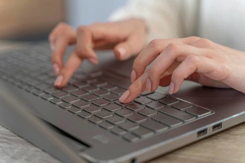 Close up woman typing laptop