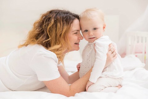 Cute baby girl playing with mother home