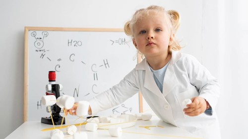 Cute toddler learning about science with whiteboard microscope