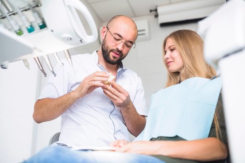 Dentist explaining dental hygiene female patient