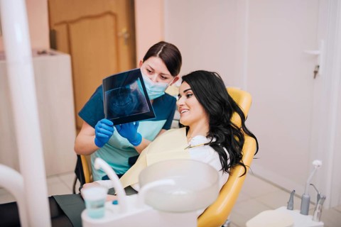 Dentist showing teeth x ray patient