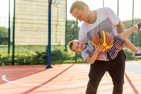 Father son playing basketball field