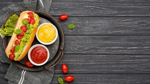 Flat lay hot dog with sauce bowls
