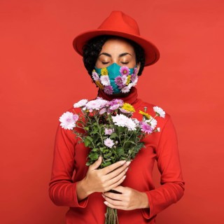 Front view woman with mask holding flowers