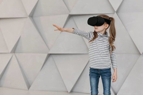 Girl wearing virtual reality headset stretching her hand