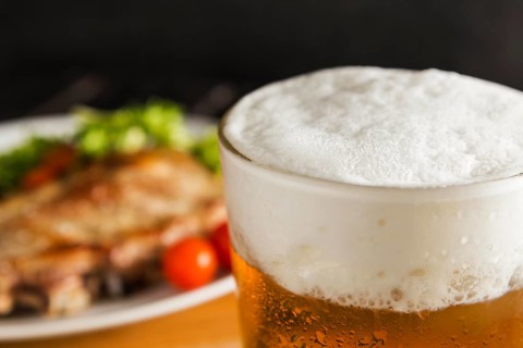 Glass beer with defocused steak